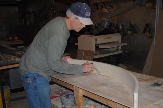 The author uses the lamination for the top rails to scribe an arc 3 1/2 inches (the width of the back-panel rail) from the inside for the radius of the rail and the panel molding. 