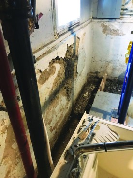 The crew cut the slab and dug a footing trench 1 foot wide and 1 foot deep. Under the wall, they dug 2-foot-wide voids 2 feet apart that would be filled with concrete as part of the new footing.