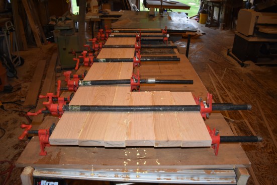 The author glued up strips of 5/4 oak alternating the grain up and down to assure stability in the tread. Alternating the bar clamps on the top and bottom helped to keep the pressure even while the glue was curing.