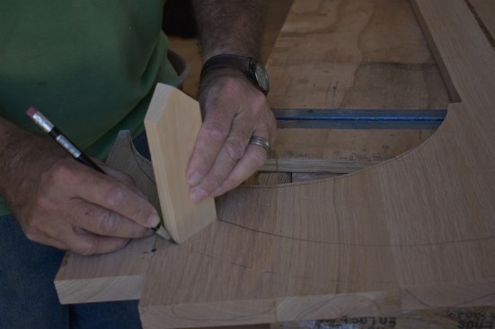 To project the scribe line to the desired overhang, the author followed the line with a 2 1/4-inch block of wood, and then cut the outside radius to that line.