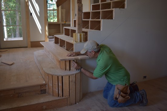 The author first measured and cut the upper stair blank to fit around the skirt boards, and then scribed the curve of the upper starter step.