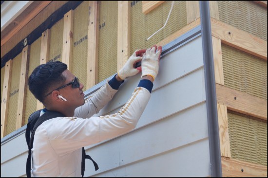 The siding crew installs Fry Reglet metal trim pieces.