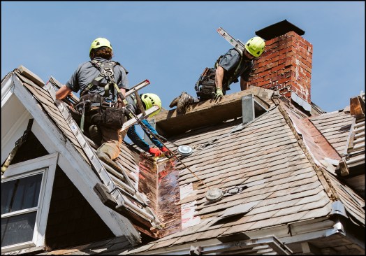 Stewardship Slate crew members install new valley and chimney flashing during a slate roof restoration project in Burlington, Vt. From left to right; Ethan Ryan, Michael Dillon and Micah Sanguedolce.