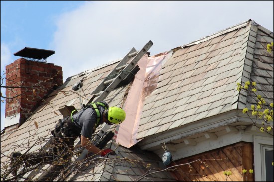 Dillon inspects the shingle alignment. New valley flashing is installed over ice barrier membrane; the roof had six valleys, three close to hips.