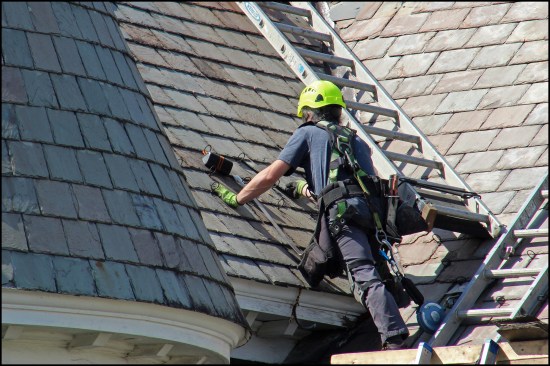 A salvaged replacement slate is slid into place and later secured with a slate hook. See “Repairing Slate Roofs,” Dec/03, for more on slate replacement.