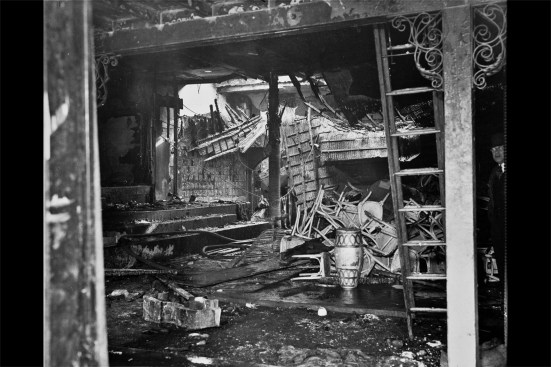 Fire damage as viewed from and the Shawmut Street entry door. The roof adjacent to a glass block partition in the main dining room is caved in. Collapsed rattan wall and ceiling coverings are seen in the background in the Caricature Bar area. (The “Caricature Bar” was filled with photographs and illustrated caricatures of celebrities and local luminaries; hence its name.)