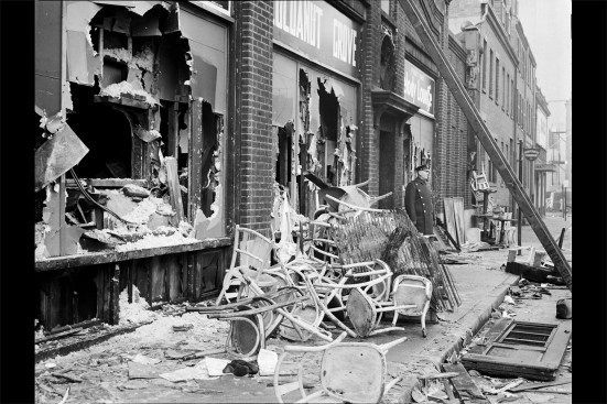 On the Shawmut Street side of the building, the exit doors were locked and the storefront windows were concealed by false walls. Here, firemen broke holes through the false walls and sheet-stock-covered glass in an effort to save patrons.