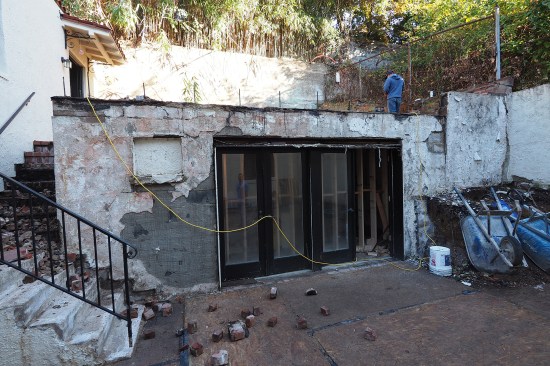 Over the years, the slab had slowly slid downhill and the top of the front wall was pushed outward roughly 2 inches. (Brick stairs leading to an apartment above the garage were also demoed. The stairs were reconfigured at top to accommodate code-approved riser heights due to higher elevation of new patio finishes.)