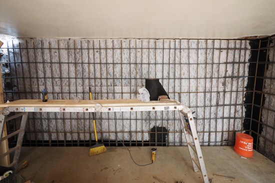 The waterproofing sheet’s horizontal seams were lapped “backward” with upper layers tucked behind lower layers in order to direct water out toward the block side of the future poured wall.