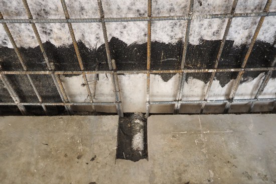 The dimple mat was set up to drain via two PVC drainpipes placed at third points along the back wall. The PVC rough-in shown here was later connected to a sub-slab pipe that drained to daylight (after liner wall was poured around it).