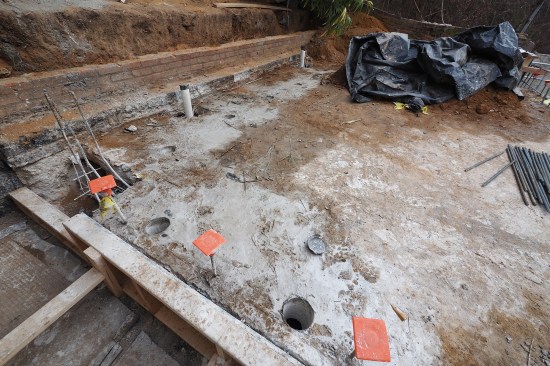 To pour the concrete for the liner walls, access holes are cored into the existing upper patio slab. 
