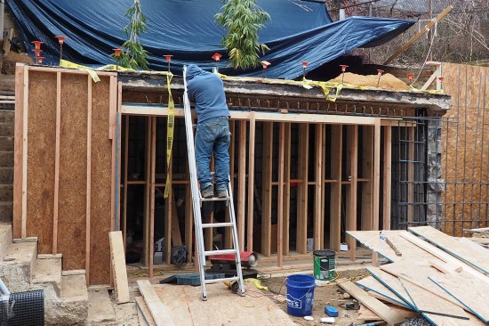Here, a crew member assembles rebar cage needed for the front wall’s reinforced concrete beam (the new beam was set below the upper patio slab).