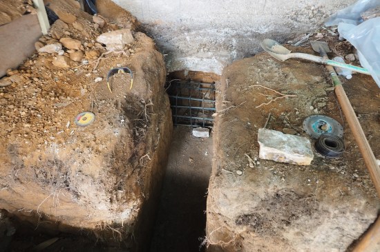 A reinforced deadman beam was formed under an existing concrete retaining wall to help hold the deadman in place and prevent it from overturning. (See illustration on main page for deadman locations.)