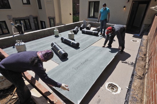 Gypsum roof underlayment was installed over a sloped polyiso foam kit (the roof slopes 1/4-inch-per-foot away from the front parapet towards two existing drain locations at rear wall).