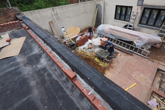 The brick parapets and retaining walls were laid up prior to installing the finish patio tile.