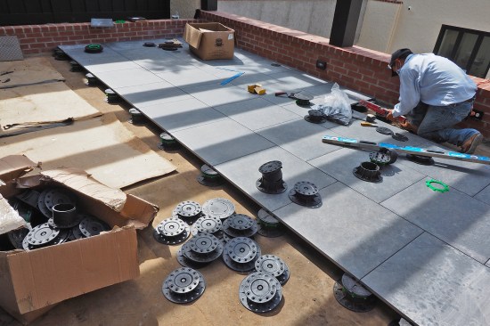 24-inch-by-24-inch-by-3/4-inch-thick ceramic tile pavers were installed on adjustable-height pedestals over a protection board.
