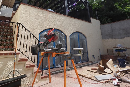 A linear drain (in the background) was installed in front of the pair of arch-top doors, outside the new exercise room. (Ground run-off water from the upper and lower patios were piped separately from the blind side drainage system to daylight.)