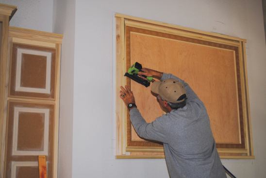 After the plywood is attached to the wall for the overmantel field, layers of ornament create a frame around the perimeter of the field.