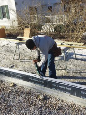 A 10-inch-wide piece of adhered-membrane flashing was bedded in a bead of acoustical sealant on top of the foundation and a second bead of sealant was applied on top of the flashing.