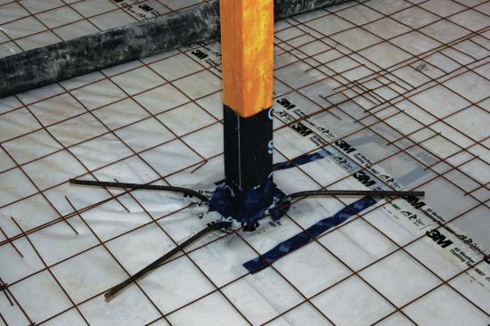 Four lengths of rebar at the corners of each footing and bent over the wire mesh integrated the post footings with the slab.