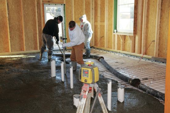 The contractor set up a laser level—in an area that was formed off to stay dry—to check the slab level as the mix was distributed and screeded.