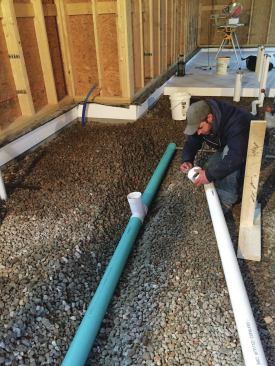A 4-inch-diameter perforated pipe ran horizontally in the 3/4-inch layer of stone and connected to a riser that exited the home through the roof, for passive radon removal. An inline fan could be added in the attic later, if needed.