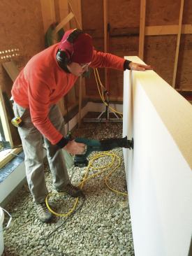 A worker finishes off the cut with a reciprocating saw. 