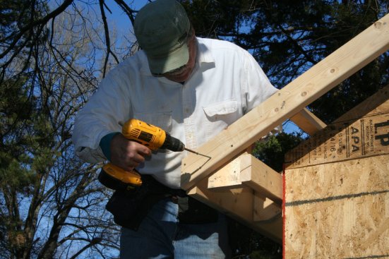 Screw a 2-by block to the back of the barge rafter and to the ledger.