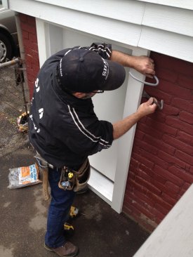 The trim compensates for the out-of-plumb foundation, leaving a space behind the trim at the top of the door. Foam backer rod is inserted into the gap before caulking is applied around the perimeter of the trim.