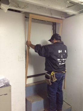 Before the foam insulation solidifies, the pre-assembled interior trim is set in place and nailed to the jambs. It fits between the sides of the opening and helps to keep the foam from expanding out past the door jamb.