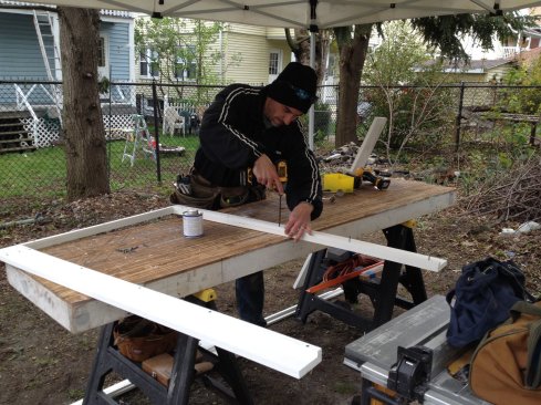 The PVC exterior trim kit is assembled on the workbench. Here a slight build out screws to the back side of the trim to compensate for the out-of-plumb foundation.