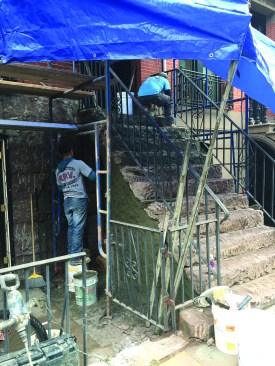Modern repair of a brownstone finish relies on three-coat concrete stucco—a more durable material than the traditional sandstone. After the old material is chipped off, reducing the stairs to a rounded but stable substrate, the repair crew builds back the stairs using a “restoration coat” of a fastsetting cement mortar.