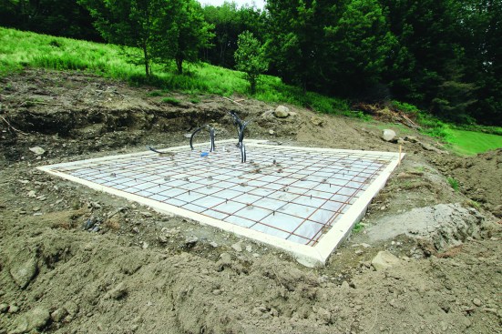 Rebar grid. A grid made from 1/2-inch rebar forms the reinforcement layer for the monolithic slab. The ends of the bar insert into the foam, and pieces of CMU act as chairs for the grid to sit on.