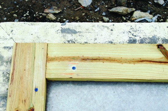 The treated sills for the walls attach to the slab with concrete screws for positioning. Embedded J-bolts around the perimeter of the slab provide
permanent anchoring for the framing.