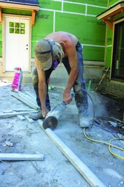 The crew cuts the cap to length with a diamond wheel on a grinder.