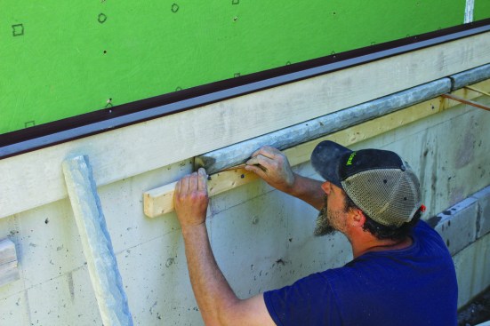 Where the foundation is not insulated, the crew installs the cap directly below the trim.