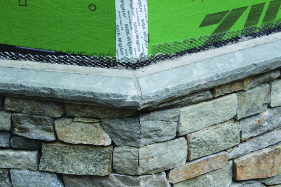 Corners are mitered, and excess lath above the cap is trimmed off after the cap is installed.