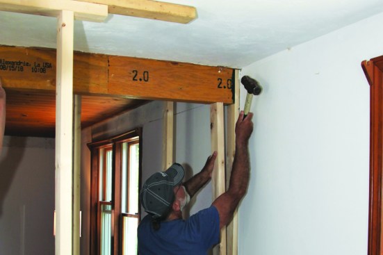 Before fastening the jacks, the author taps the beam into alignment with the rest of the framing.
