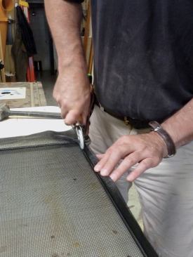 We measured and cut the lengths, then assembled the frame. The face of the screen extrusion has a groove that captures the screen with a spline that is pressed into the groove. Because the owners of this house had a large dog, we fitted the frame with a heavier than normal fiberglass screen sold as "pet screen."