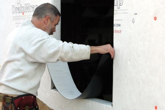 After removing the release paper, I make sure the membrane is centered in the opening... 
Note: Flashing membranes are meant to be installed at temperatures of 45 degrees or above. In colder weather, I keep the flashing in a warm place and cut pieces as I need them.