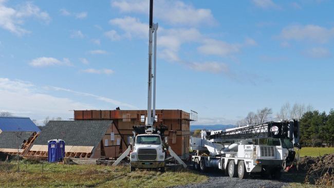 On roof-raising day, two cranes arrived at 8 a.m.; one small (10 tons) to set the steel rails, the larger (40 tons) to do the heavy lifting. Spectators came as well. Though this home is in the country, neighbors with digital camcorders appeared and passing vehicles slowed to a crawl so that drivers could watch.