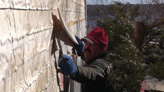 The general contractor’s crew strips the existing clapboards off the building.