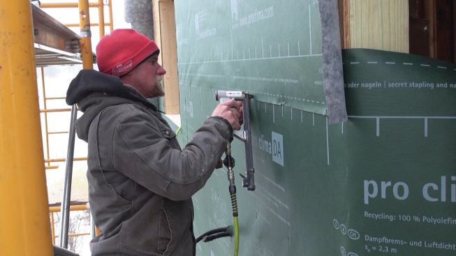 The Pro Clima DA membrane is stapled to the wall. Air-sealing tape is then applied over the staple lines.