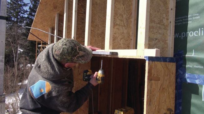 After I-joists have been installed against the walls, the crew adds blocking around the bucks to complete the rough window frame.