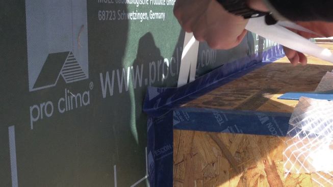 To preserve the air barrier at the windows, the crew applies Tescon Vana tape to the corners of the window bucks.