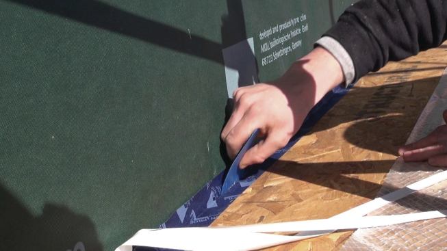 Pressing the tape down with a plastic tool activates the adhesive in the vapor-open tape.