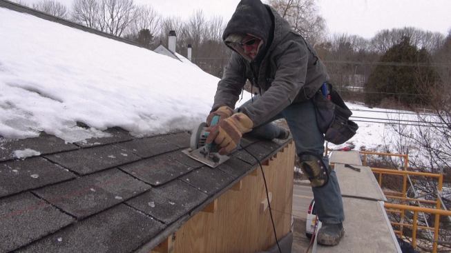 The crew cut the existing roof eaves back flush to the wall, using a circular saw to cut through the roofing and sheathing.