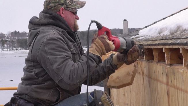 A recip saw is used to cut the rafters flush with the wall sheathing.