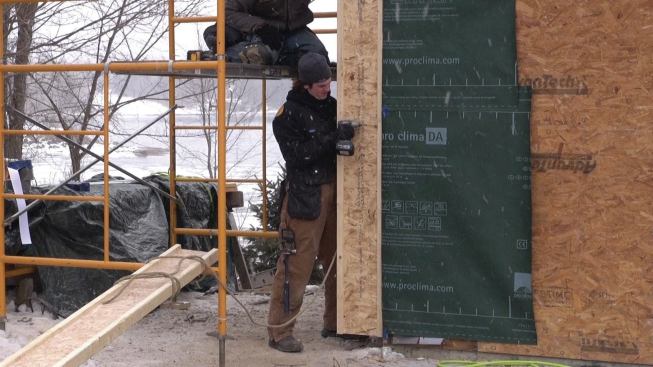 The crew screwa the I-joists to the wall at stud locations.