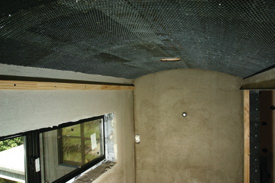 To waterproof the ceiling, a layer of cold-patch tar is spread over the green board followed by a layer of 30-pound felt paper. Wire mesh is then nailed in over the entire surface.